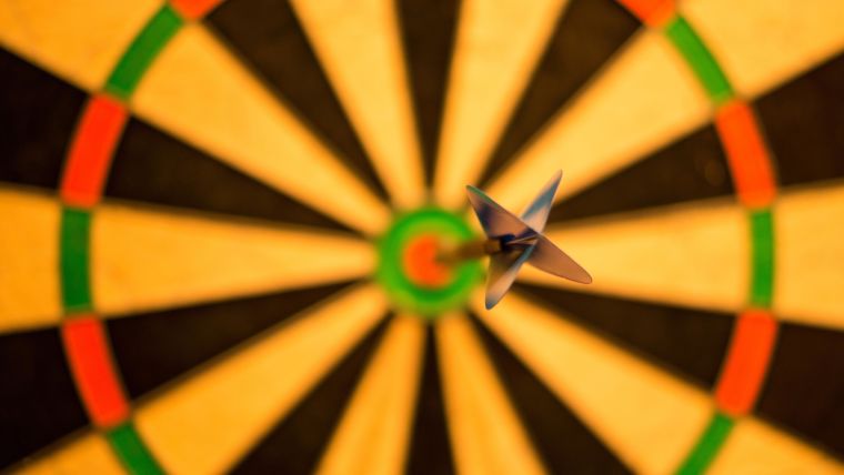 Photographs of a dart board with a dart positioned in the bullseye